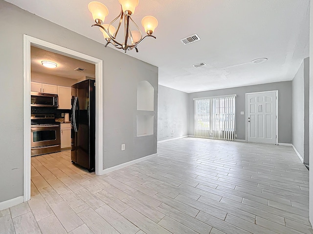 1201 Susan St, Leesburg, FL 34748 - interior space featuring visible vents, baseboards, light wood finished floors, and a chandelier