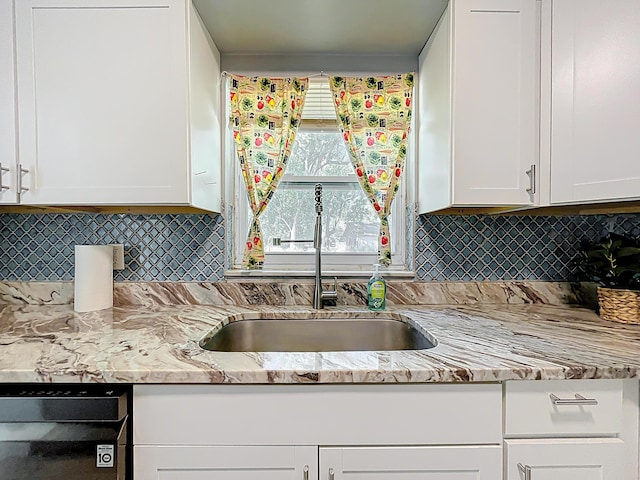 1201 Susan St, Leesburg, FL 34748 - kitchen featuring a sink, backsplash, white cabinets, and black dishwasher