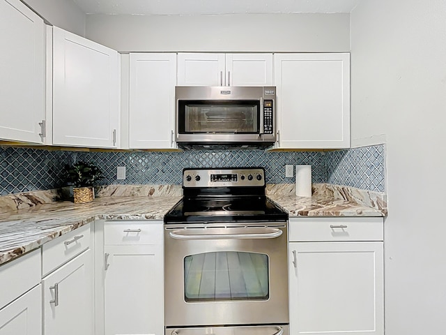 1201 Susan St, Leesburg, FL 34748 - kitchen with stainless steel appliances, tasteful backsplash, white cabinetry, and light stone counters