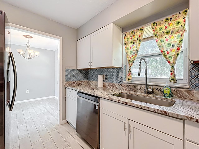 1201 Susan St, Leesburg, FL 34748 - kitchen with decorative backsplash, a sink, a notable chandelier, and stainless steel appliances