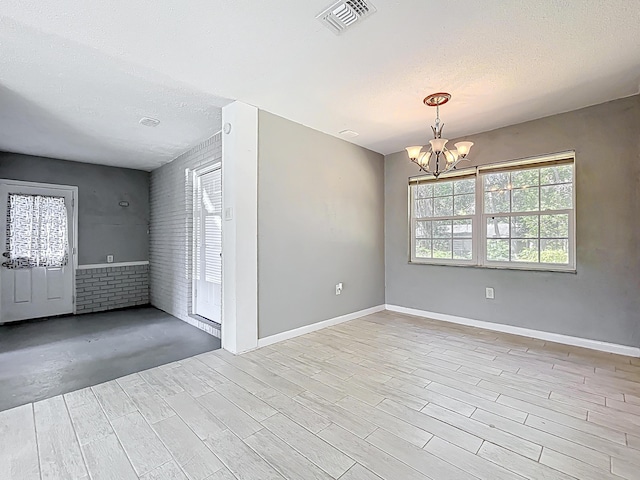 1201 Susan St, Leesburg, FL 34748 - empty room with a chandelier, a textured ceiling, visible vents, and light wood-style flooring