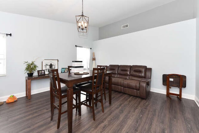 dining room with a barn door, baseboards, visible vents, an inviting chandelier, and wood finished floors