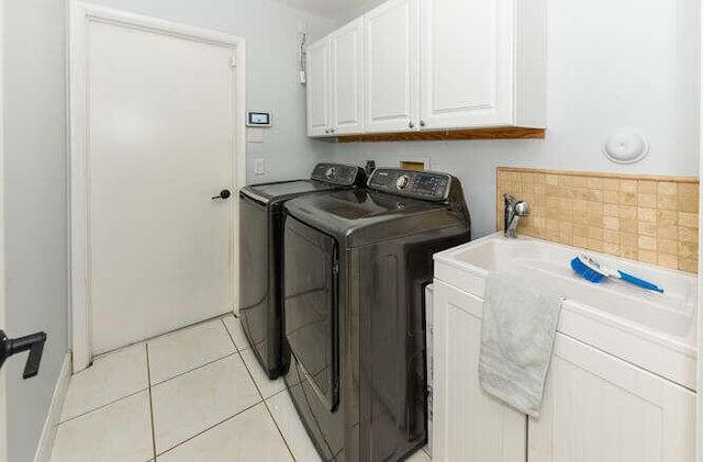 laundry room with cabinet space, washer and clothes dryer, and light tile patterned flooring