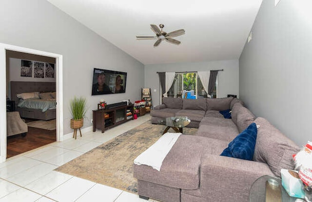 living room featuring lofted ceiling, a ceiling fan, and tile patterned floors