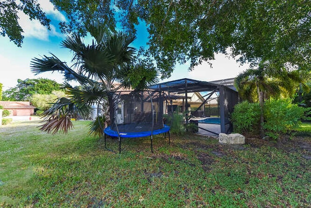 view of yard featuring an outdoor pool and glass enclosure