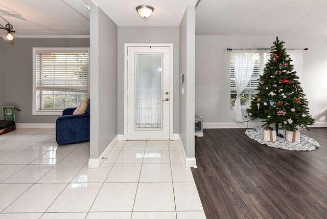 entrance foyer featuring crown molding, baseboards, and tile patterned floors