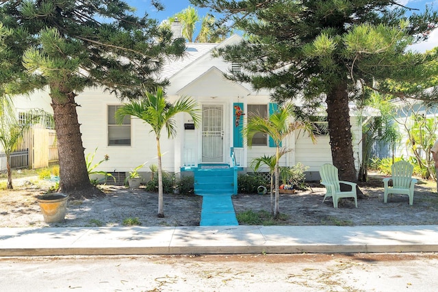 view of front of home with a chimney and fence