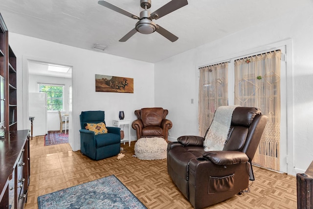 sitting room with visible vents, baseboards, and ceiling fan