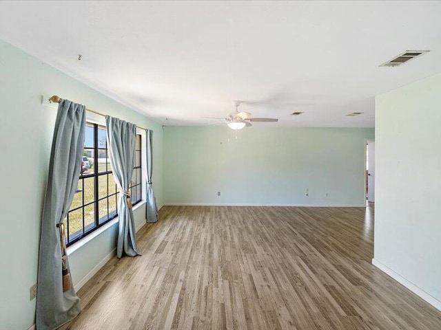 1821 SE Hanby Ave, Port Saint Lucie, FL 34952 - empty room with light wood-style flooring, a ceiling fan, and baseboards