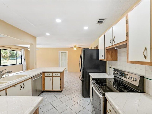 1821 SE Hanby Ave, Port Saint Lucie, FL 34952 - kitchen featuring appliances with stainless steel finishes, a sink, tile counters, decorative backsplash, and recessed lighting