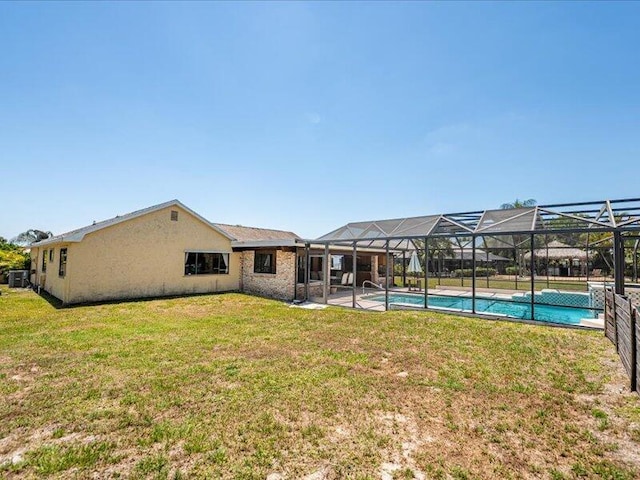 1821 SE Hanby Ave, Port Saint Lucie, FL 34952 - rear view of house with a yard, an outdoor pool, and glass enclosure