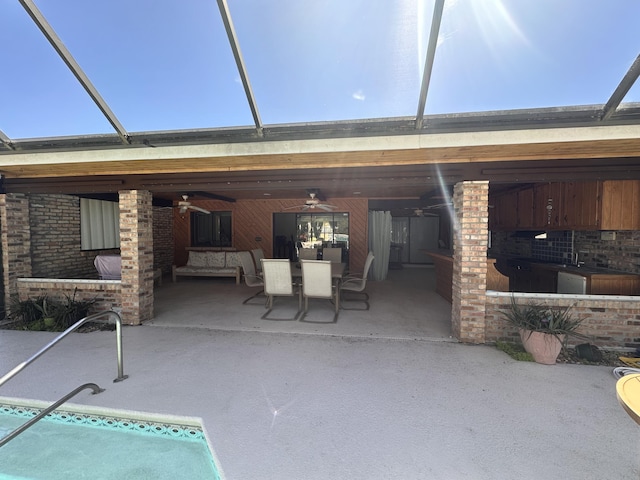 view of patio with a lanai, ceiling fan, and outdoor dining space