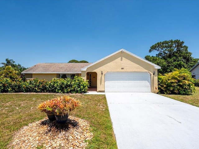 1821 SE Hanby Ave, Port Saint Lucie, FL 34952 - ranch-style house with a garage, a front yard, driveway, and stucco siding