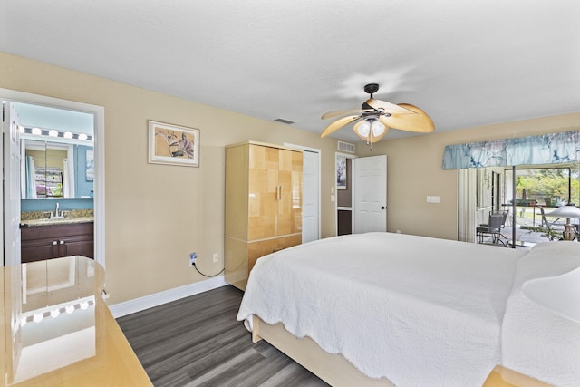 bedroom featuring dark wood-style flooring, a sink, visible vents, and baseboards