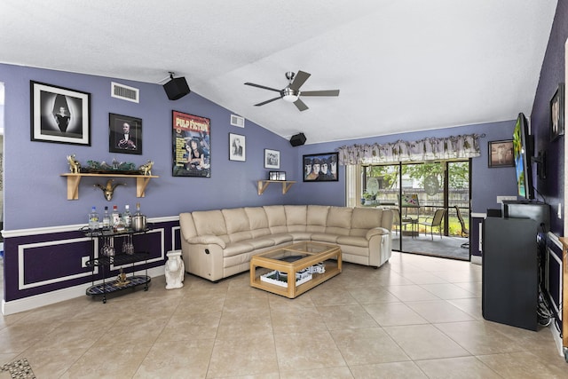 living area featuring vaulted ceiling, tile patterned flooring, visible vents, and a ceiling fan