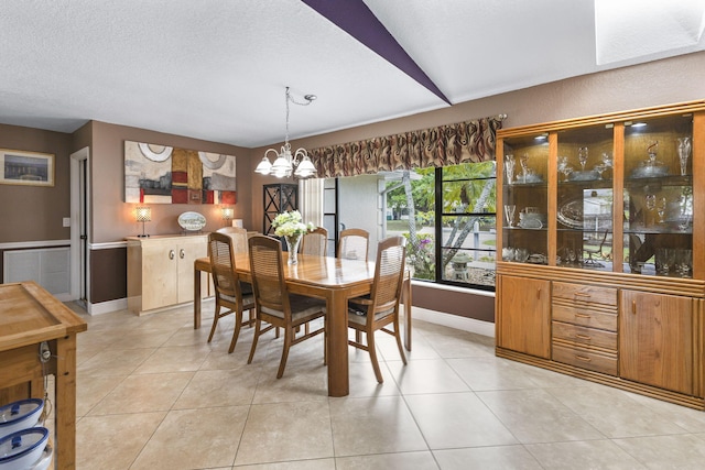 dining space featuring a chandelier, a textured ceiling, light tile patterned flooring, and visible vents