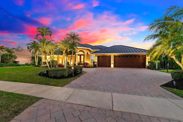 15730 Cedar Grove Ln, Wellington, FL 33414 - view of front of house featuring a front yard, a standing seam roof, an attached garage, metal roof, and decorative driveway