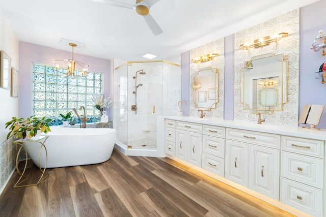 15730 Cedar Grove Ln, Wellington, FL 33414 - bathroom featuring a soaking tub, a shower stall, double vanity, wood finished floors, and a sink
