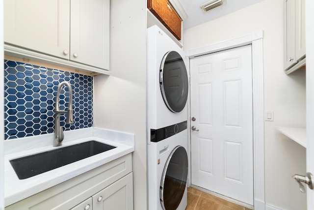 15730 Cedar Grove Ln, Wellington, FL 33414 - laundry area featuring a sink, visible vents, stacked washer / drying machine, and cabinet space