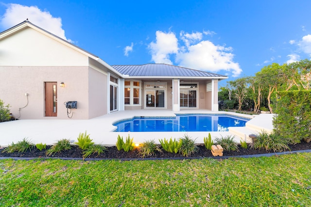 15730 Cedar Grove Ln, Wellington, FL 33414 - rear view of house featuring a patio area, stucco siding, metal roof, an outdoor pool, and a yard