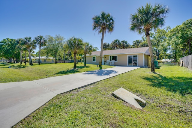 exterior space featuring a front lawn, fence, and driveway