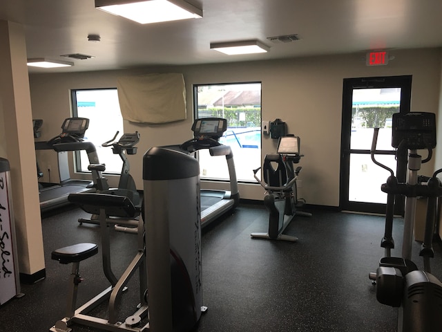 exercise room with baseboards and visible vents