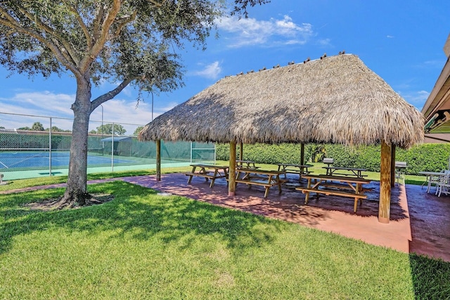 surrounding community featuring a yard, a tennis court, fence, and a gazebo