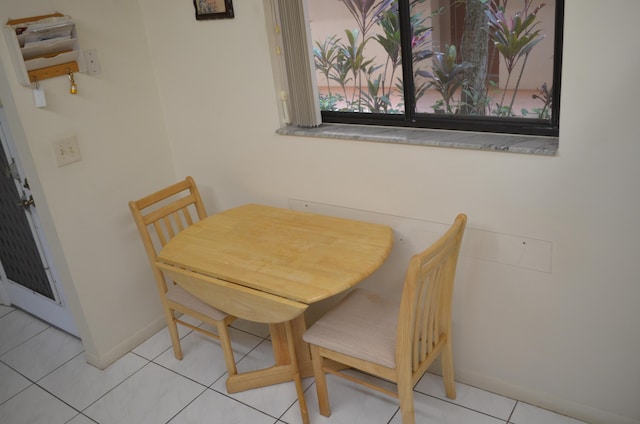 dining space featuring baseboards and light tile patterned floors