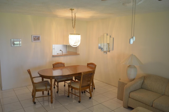 dining space featuring a textured ceiling and light tile patterned floors