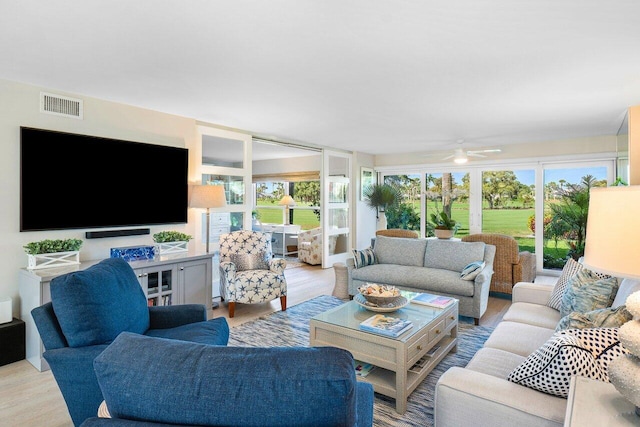 living room with a healthy amount of sunlight, light wood-style floors, visible vents, and a ceiling fan