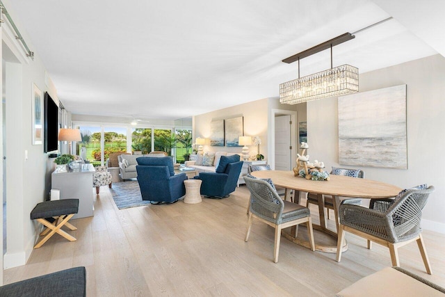 dining area featuring light wood-type flooring and baseboards