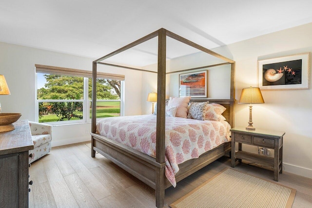 bedroom with light wood-style floors and baseboards