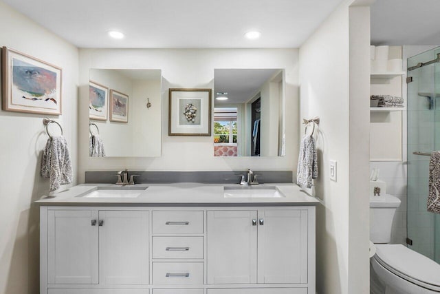 full bathroom with a tile shower, double vanity, and a sink