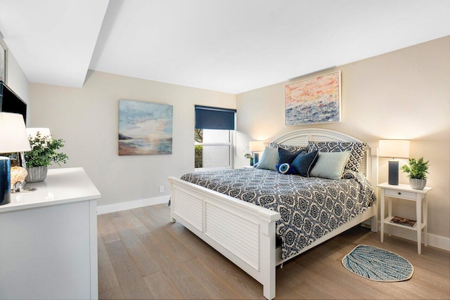 bedroom featuring baseboards and light wood-style floors