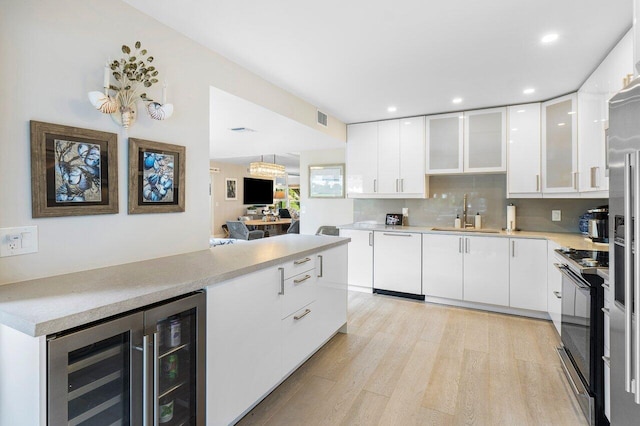 kitchen with dishwasher, wine cooler, black range with electric stovetop, white cabinetry, and a sink