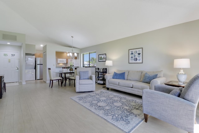 living room with light wood-style flooring, visible vents, and a notable chandelier