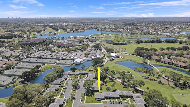 drone / aerial view featuring golf course view, a water view, and a residential view