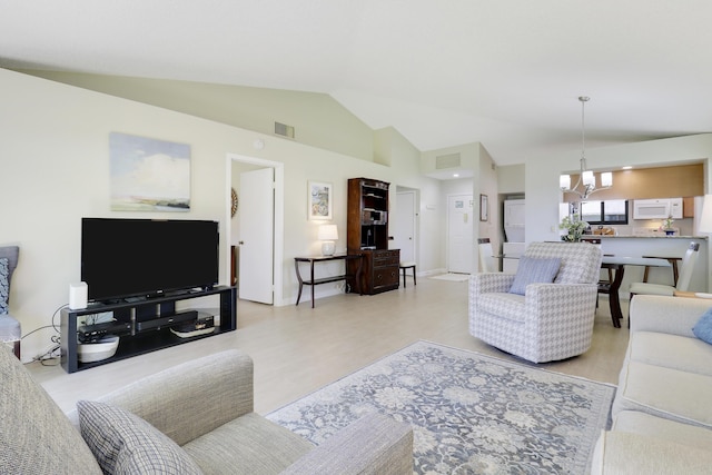 living room with high vaulted ceiling, light wood finished floors, visible vents, and a notable chandelier