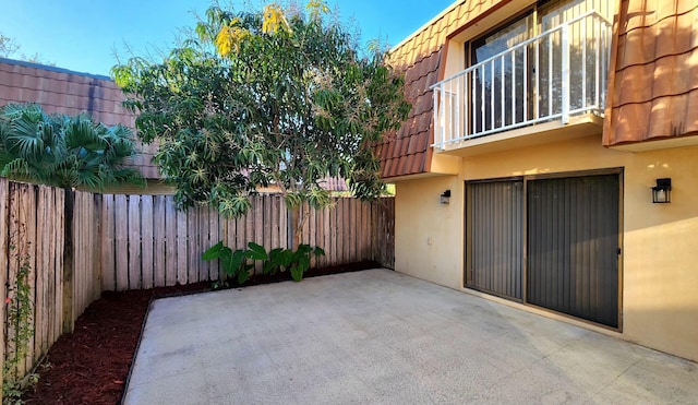 view of patio featuring a fenced backyard and a balcony