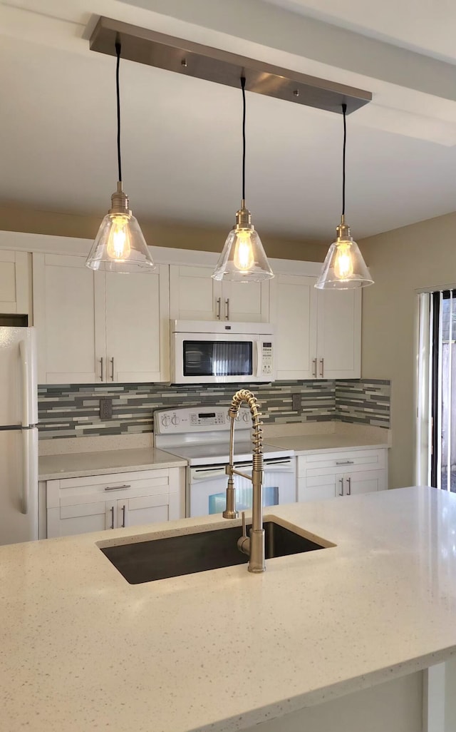 kitchen featuring white appliances, backsplash, and white cabinets