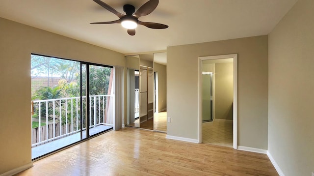 spare room featuring light wood-type flooring, baseboards, and a ceiling fan