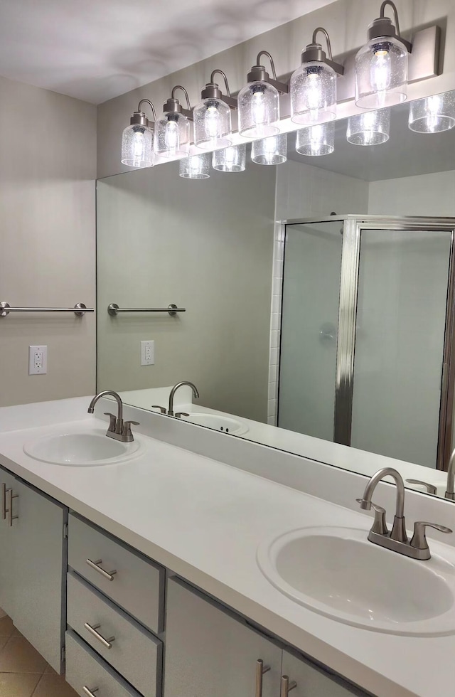 bathroom featuring double vanity, a shower stall, and a sink