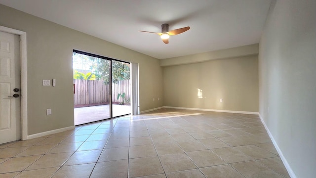 unfurnished room with light tile patterned floors, ceiling fan, and baseboards