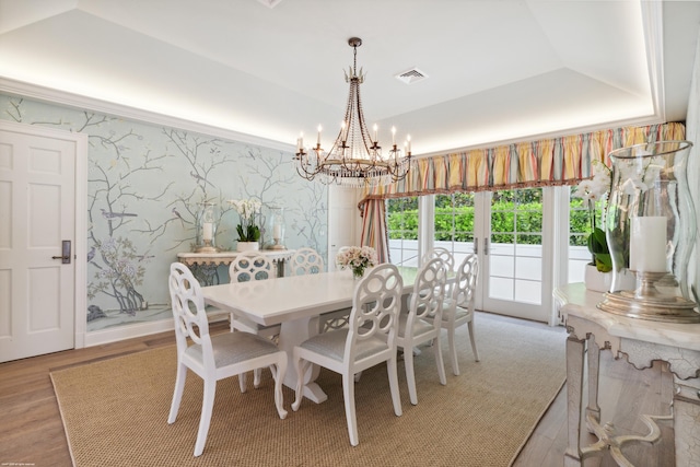 dining area featuring light wood-type flooring, wallpapered walls, visible vents, and a tray ceiling