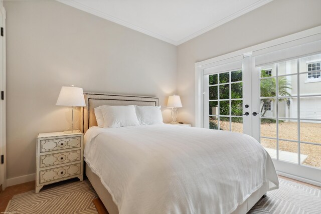 bedroom with baseboards, access to outside, multiple windows, and crown molding