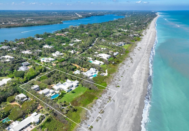 birds eye view of property with a water view and a view of the beach