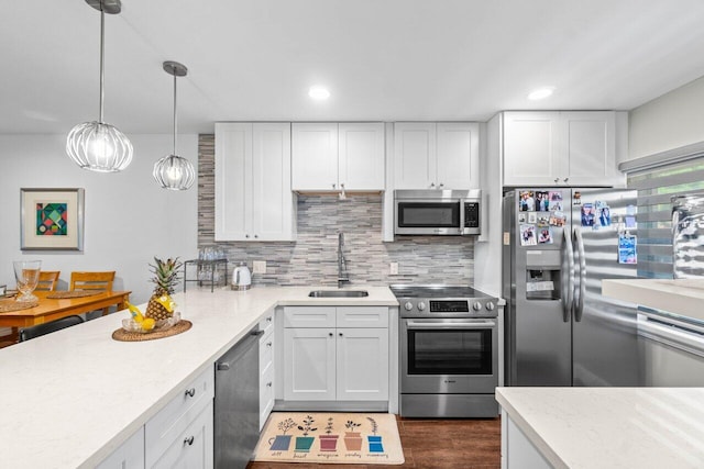 kitchen with stainless steel appliances, a sink, white cabinetry, hanging light fixtures, and tasteful backsplash