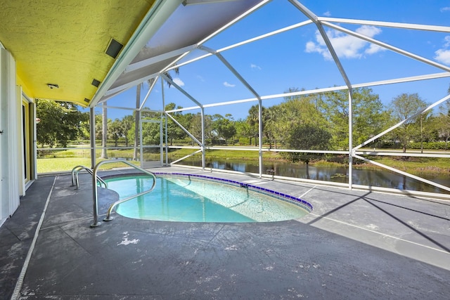 outdoor pool featuring a patio, a water view, and a lanai