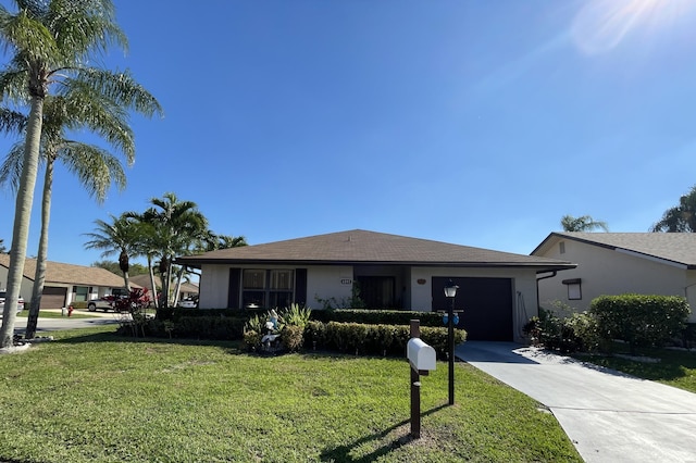 view of front of house featuring driveway, stucco siding, an attached garage, and a front yard