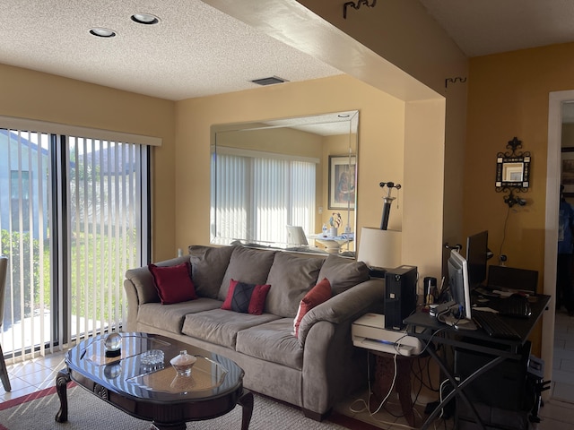 tiled living area featuring a textured ceiling, visible vents, and a healthy amount of sunlight